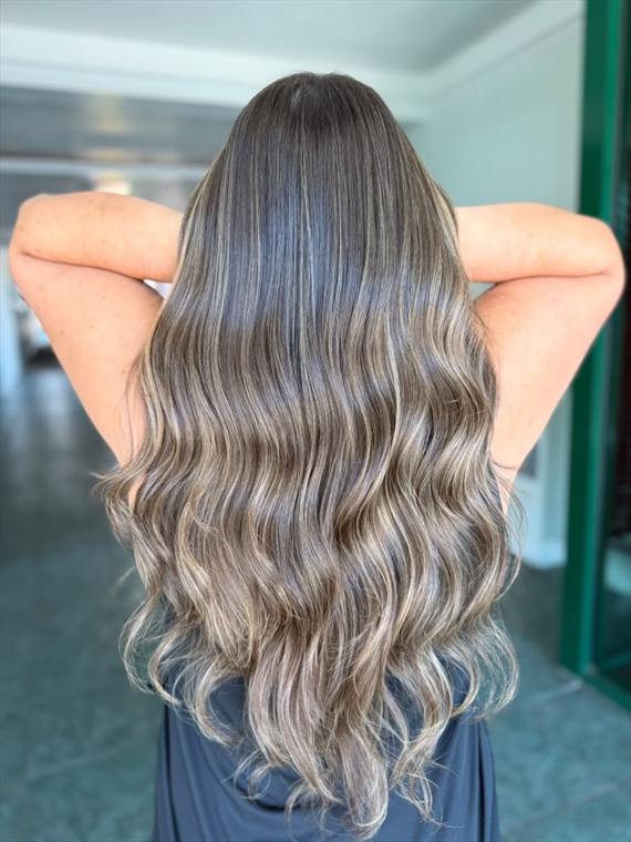Cool ash-blonde and silver balayage melting from a dark brunette root on long hair