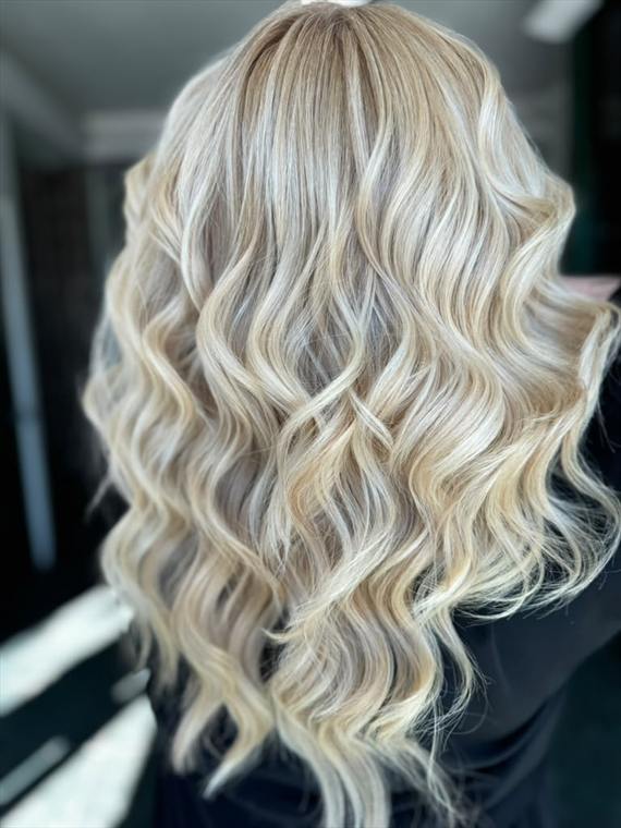 Bright beige-blonde balayage with a soft root shadow on long, voluminous waves