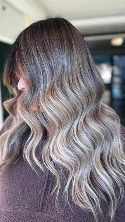 Ash mushroom-brown melting to silver-blonde balayage on long styled waves