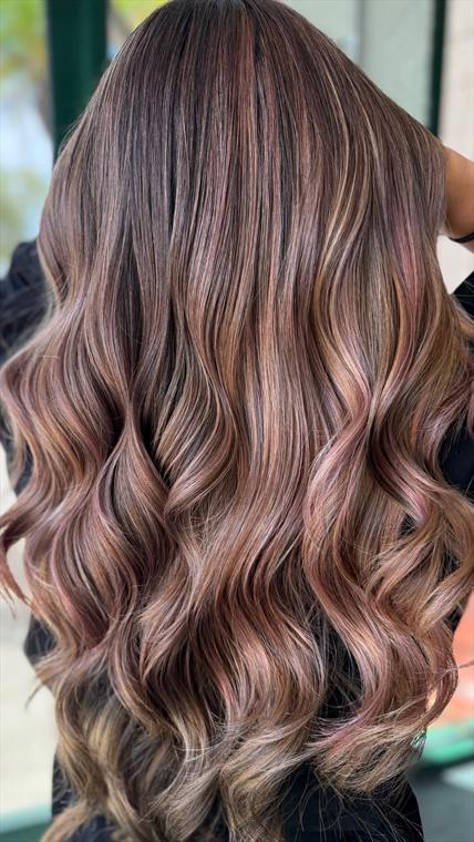 Dusky rose-mauve and copper balayage over a dark brunette base on long waves